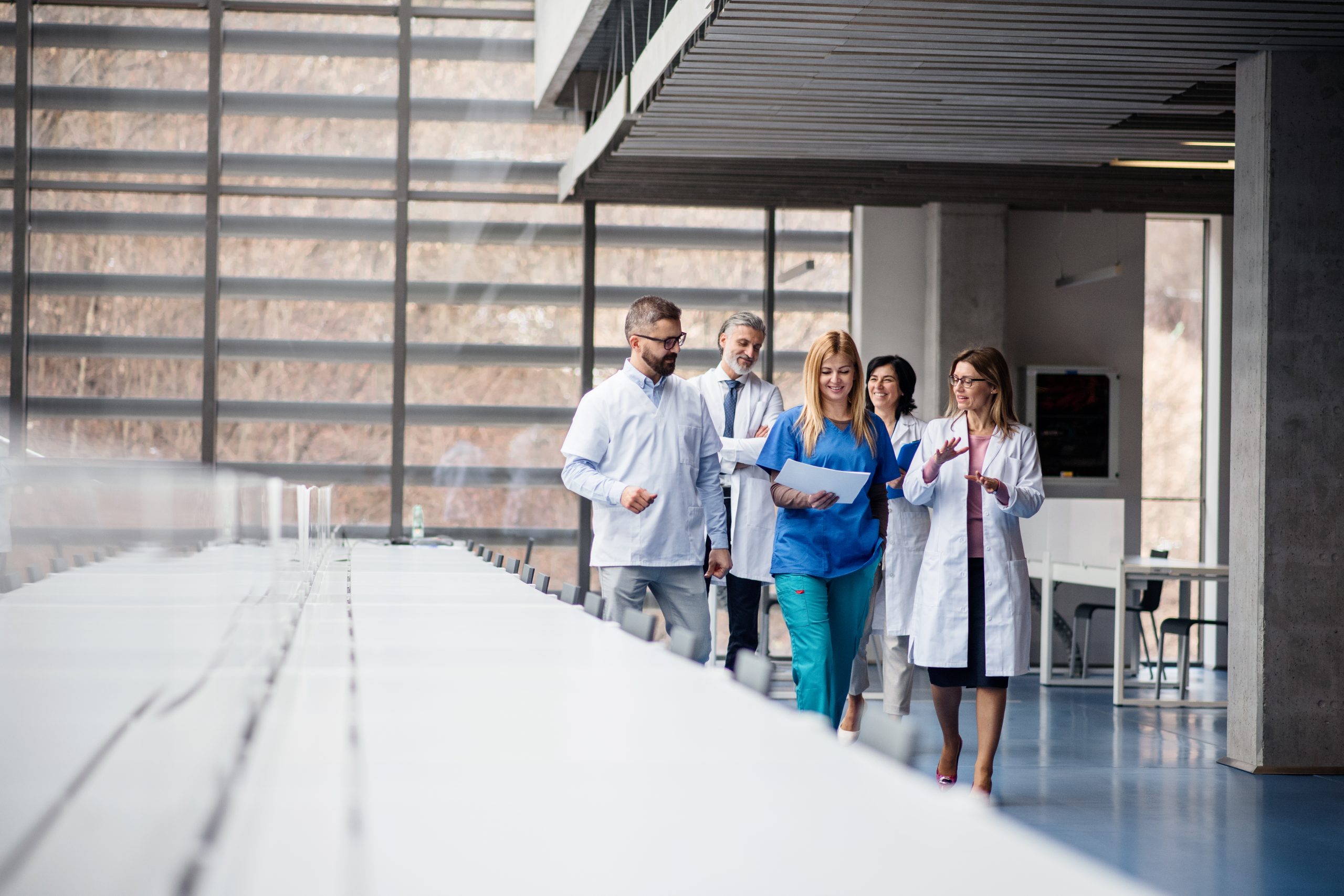 Group of doctors walking in corridor on medical conference.